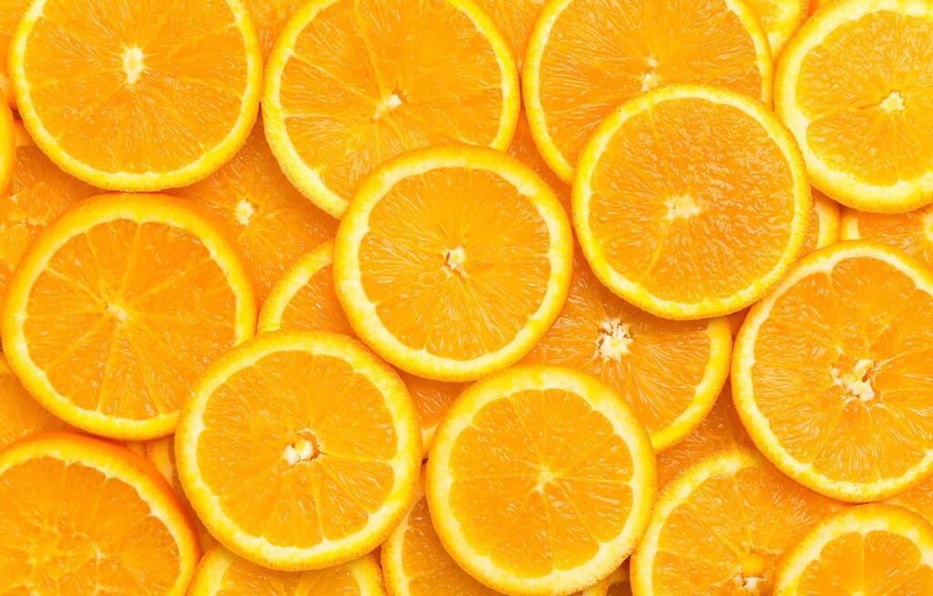 Pokrojone świeże pomarańcze układające się ciasno, pokazujące soczyste cząstki, skuteczne metody leczenia NTM poprzez dietę.